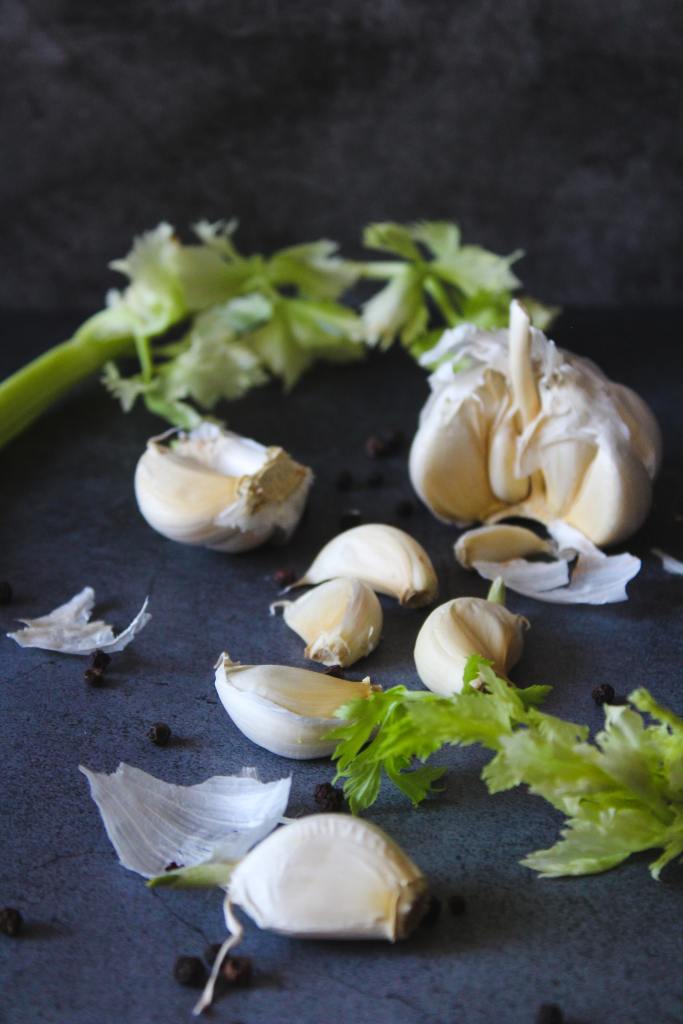 Cloves of garlic on a dark surface.